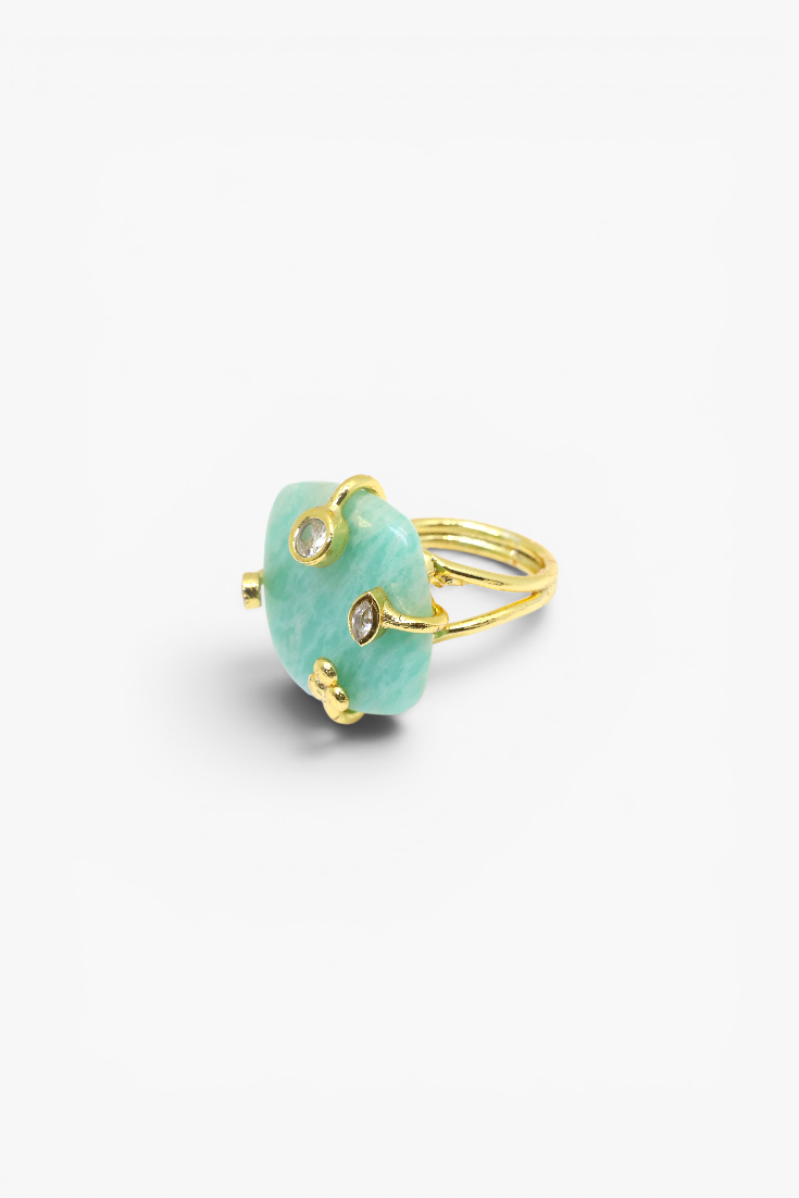Gold ring with a green gemstone on a white background