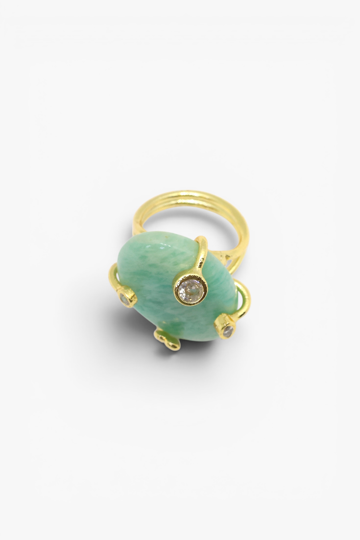Ring with a green gemstone and gold accents on a white background