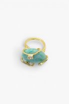 Gold ring with a green stone on a white background