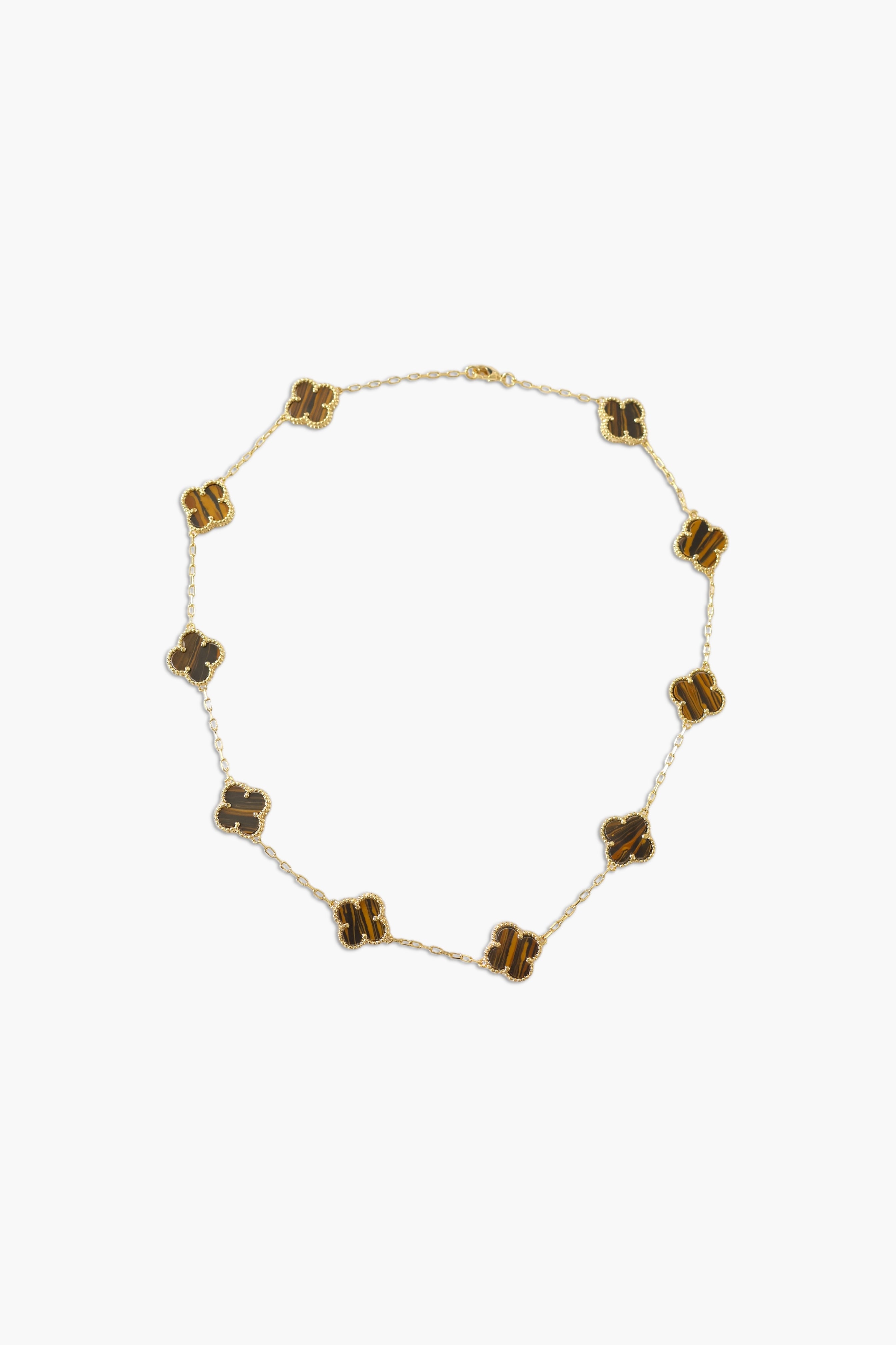 A person wearing multiple necklaces with amethyst stones and gold accents. The necklaces are part of a stack, and the person is holding some of the necklaces, showcasing the jewelry.