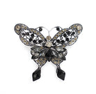 Butterfly-shaped brooch with gemstones on a white background
