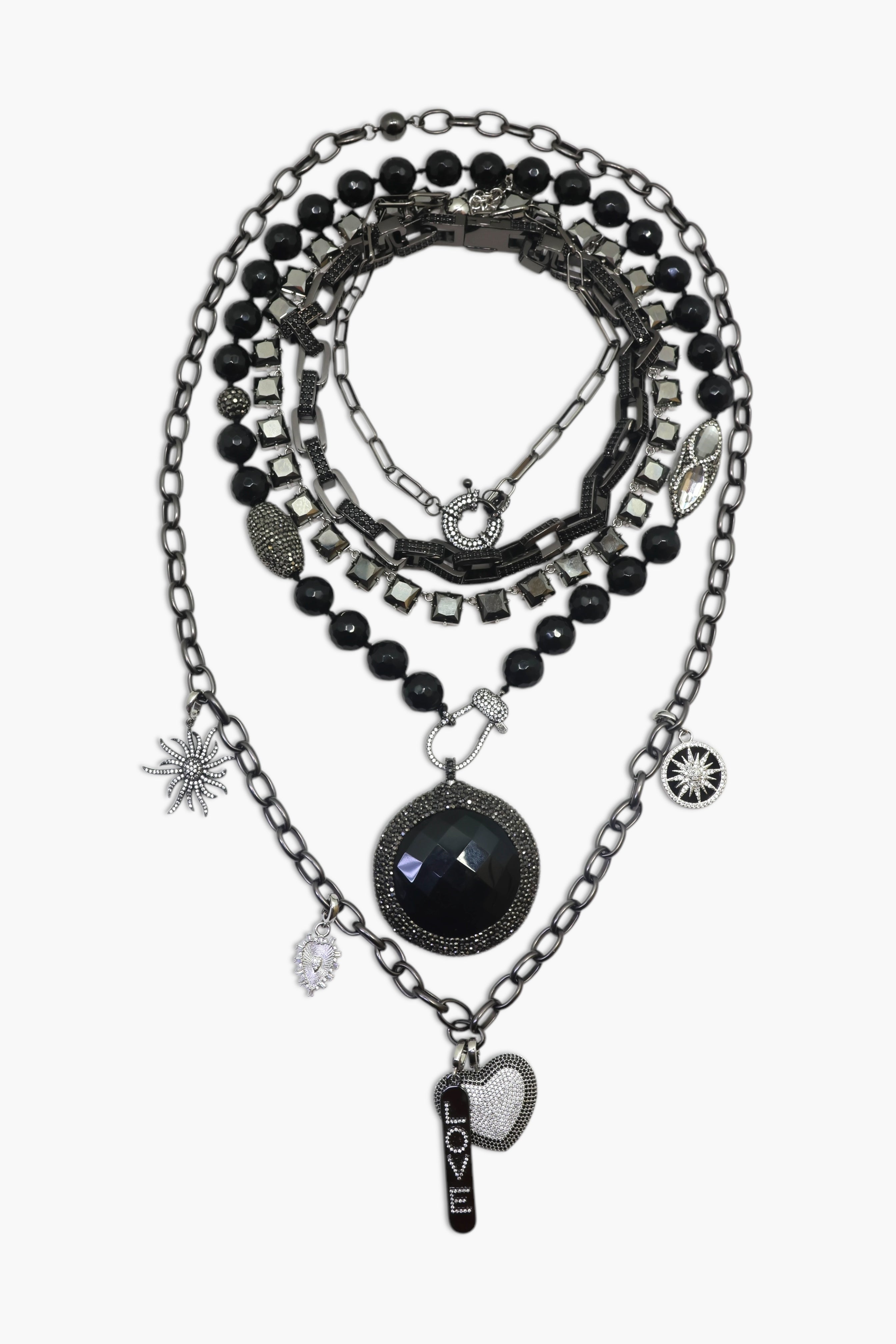 A person wearing multiple necklaces with onyx and gun metal colors.