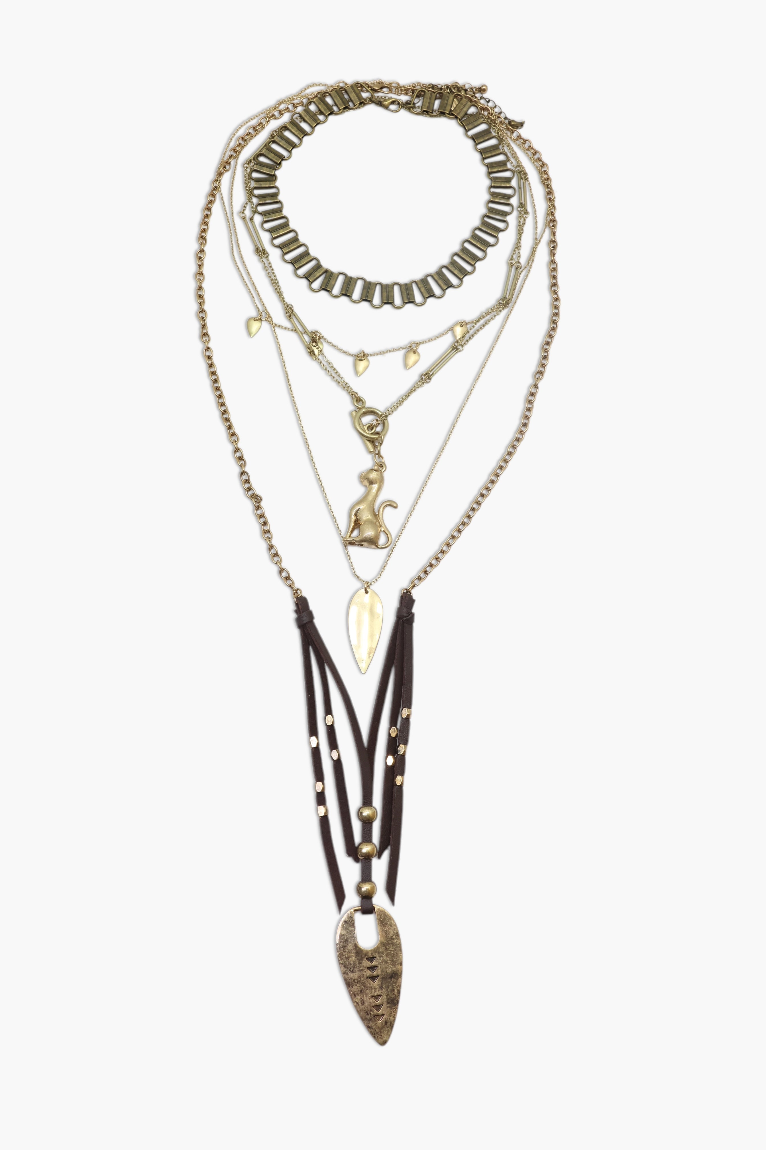 A layered brass necklace with various geometric shapes and a prominent arrowhead design.