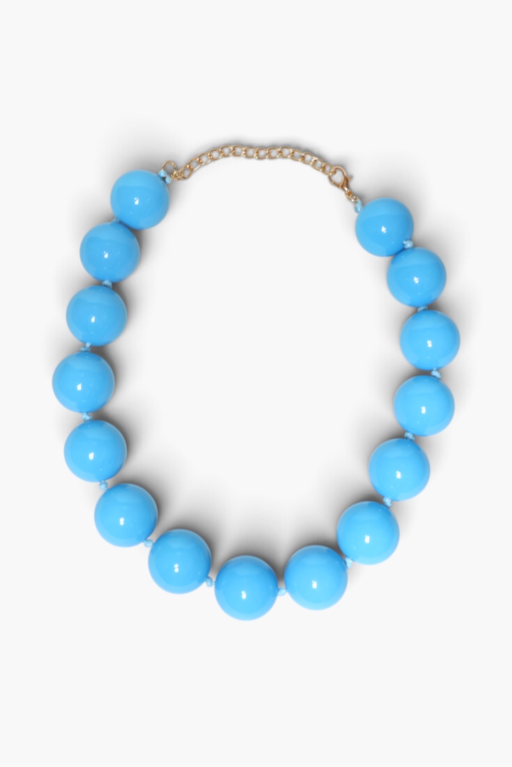 A light blue beaded necklace with large glossy round beads and a gold-tone chain extender clasp, displayed on a clean white background.