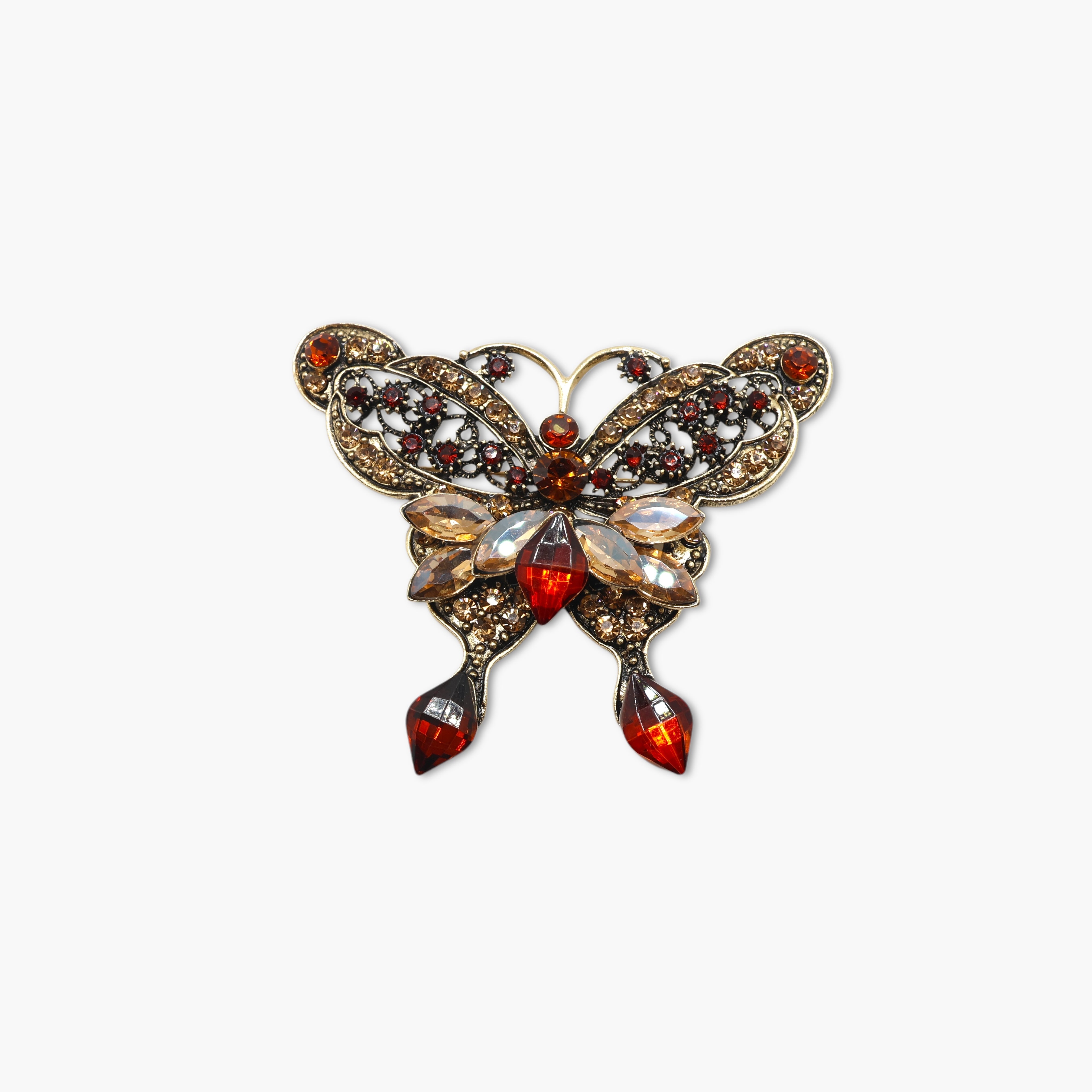 Butterfly-shaped brooch with gemstones on a white background