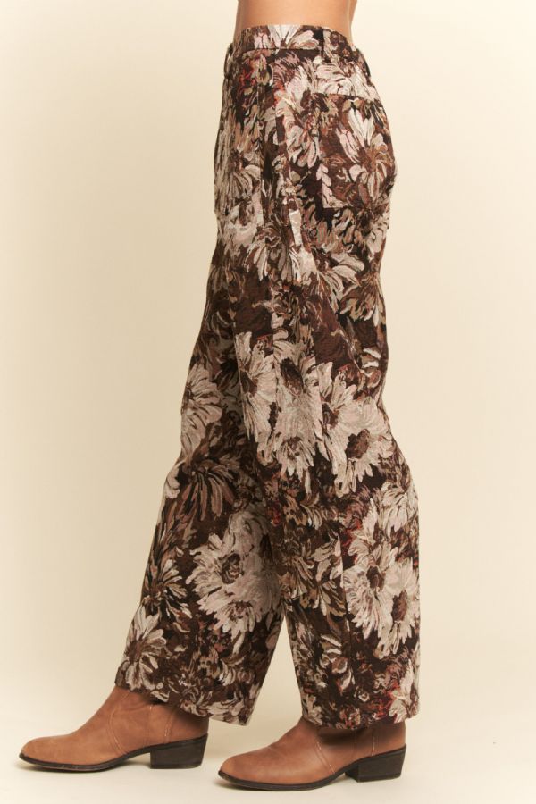 Floral patterned pants worn by a person on a beige background