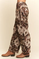 Floral patterned pants worn by a person on a beige background