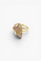 Natural stone statement ring with crystal accents in a gold-tone setting featuring an organic gemstone design.