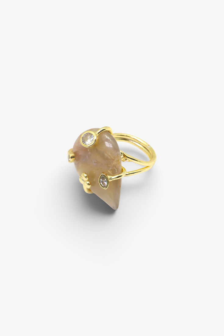 Natural stone statement ring with crystal accents in a gold-tone setting featuring an organic gemstone design.