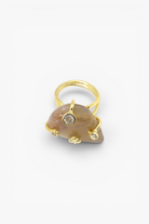 Natural stone statement ring with crystal accents in a gold-tone setting featuring an organic gemstone design.