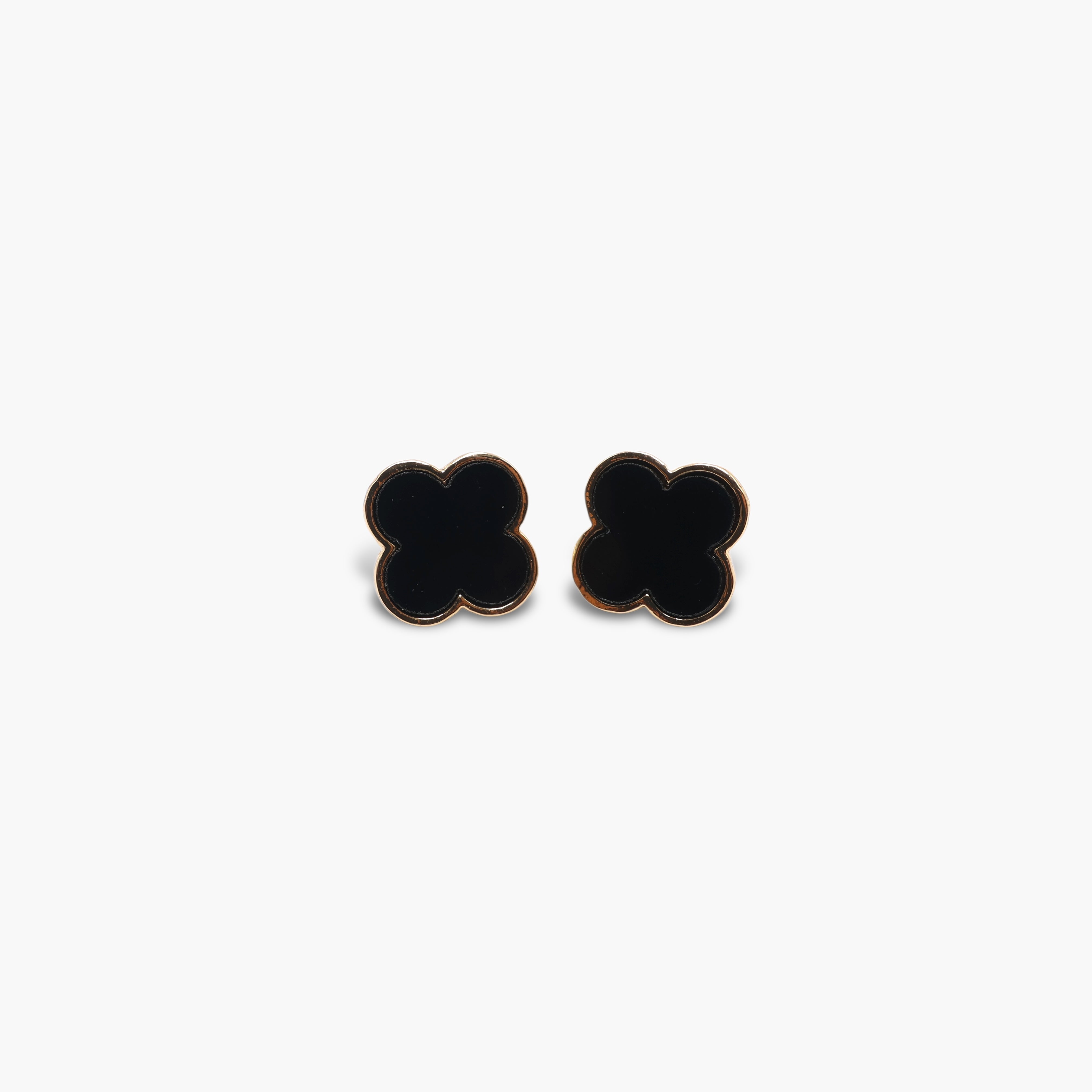 A pair of black stud earrings shaped like clovers.