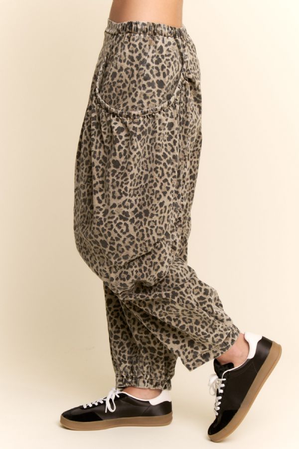 Leopard print pants worn by a person on a beige background