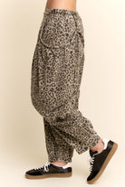 Leopard print pants worn by a person on a beige background