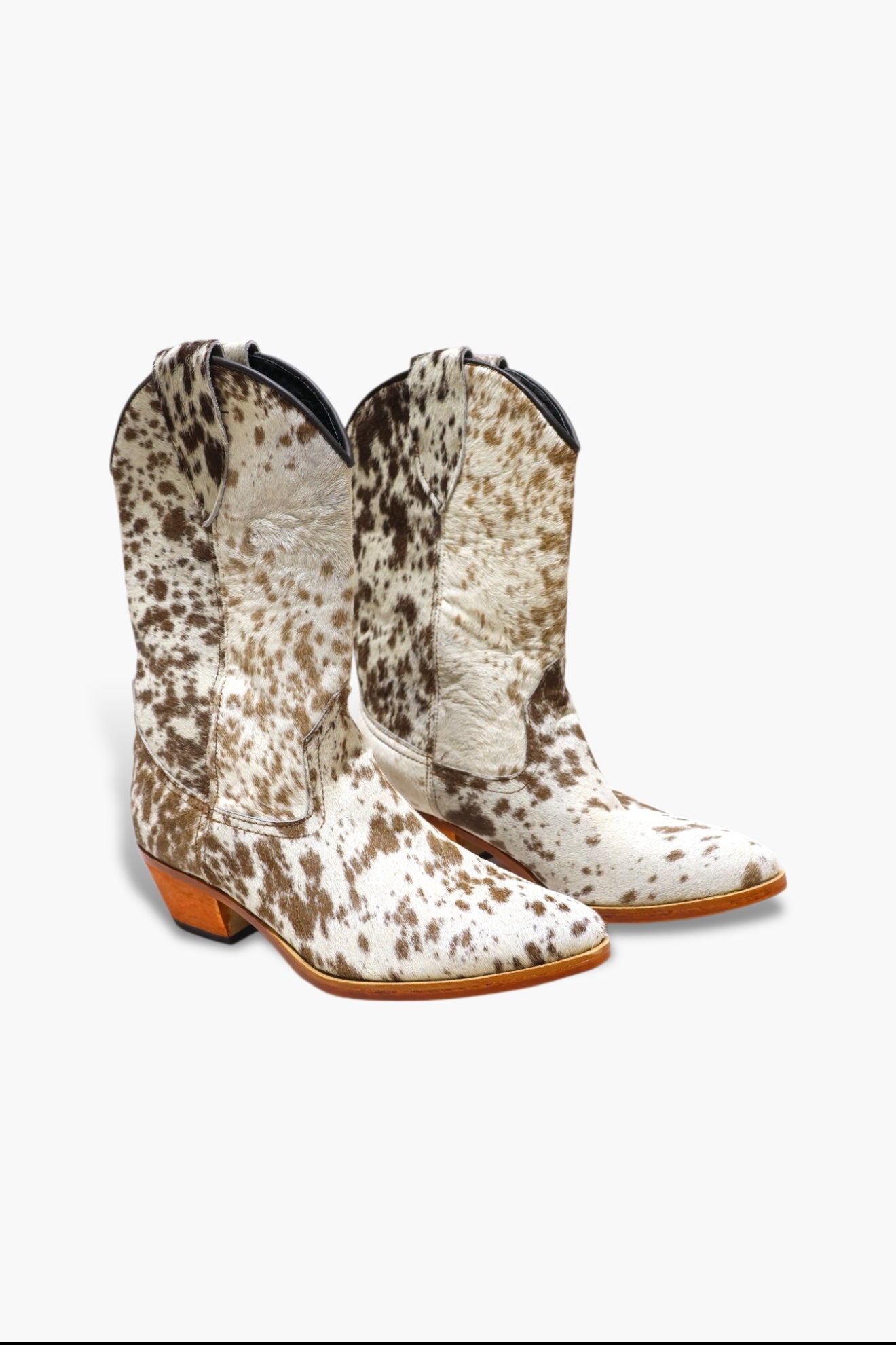Pair of cow print cowboy boots on a white background