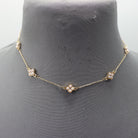 Gold necklace with pearl-like beads on a mannequin bust.