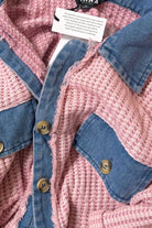 Women’s waffle knit button front romper with collared neckline, utility pockets, rolled short sleeves, and relaxed fit casual one-piece outfit for boutique fashion.
