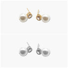 A pair of pearl ball earrings, one with a gold-colored band and the other with a silver-colored band, against a white background.