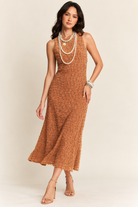 Brown sleeveless midi dress with an intricate textured pattern, subtle shimmer, and a flowing A-line silhouette, styled with layered pearl necklaces, bracelets, and nude strappy heels.