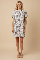 Woman wearing a floral dress against a beige background
