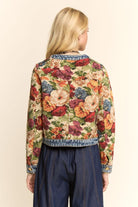 Woman wearing a floral jacket with a beige background