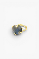 Gold ring with a blue gemstone on a white background