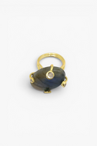 Gold ring with a large blue stone on a white background