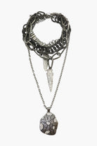 A gunmetal necklace with double arrow design and multiple layers, featuring a large pendant.