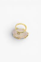 Natural stone statement ring with crystal accents in a gold-tone setting featuring an organic gemstone centerpiece.