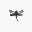 Dragonfly-shaped brooch with gemstones on a white background
