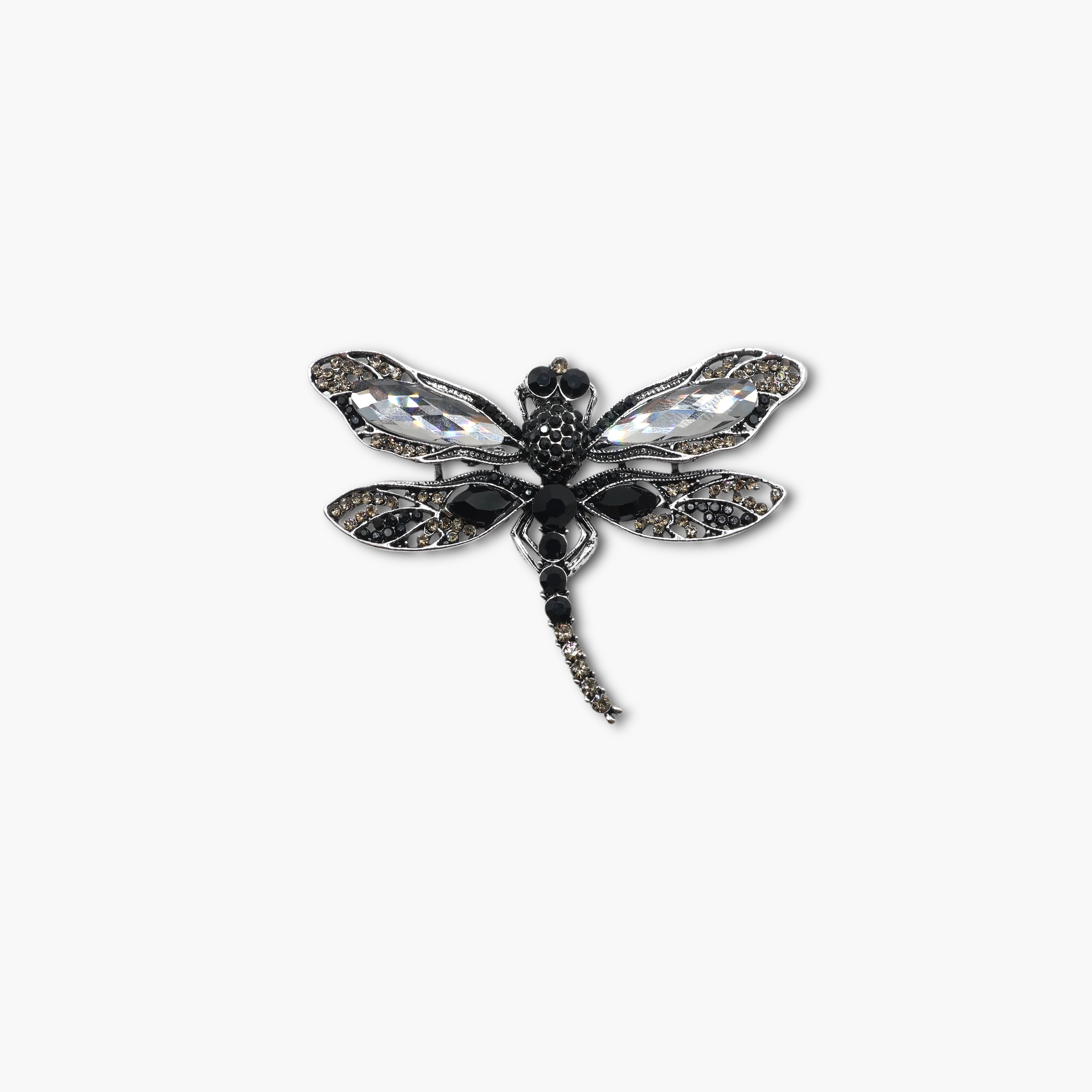 Dragonfly-shaped brooch with gemstones on a white background