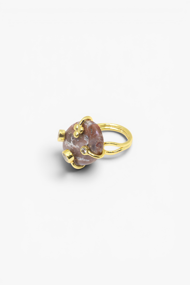 Natural stone statement ring with crystal accents in a gold-tone setting featuring an organic gemstone design.