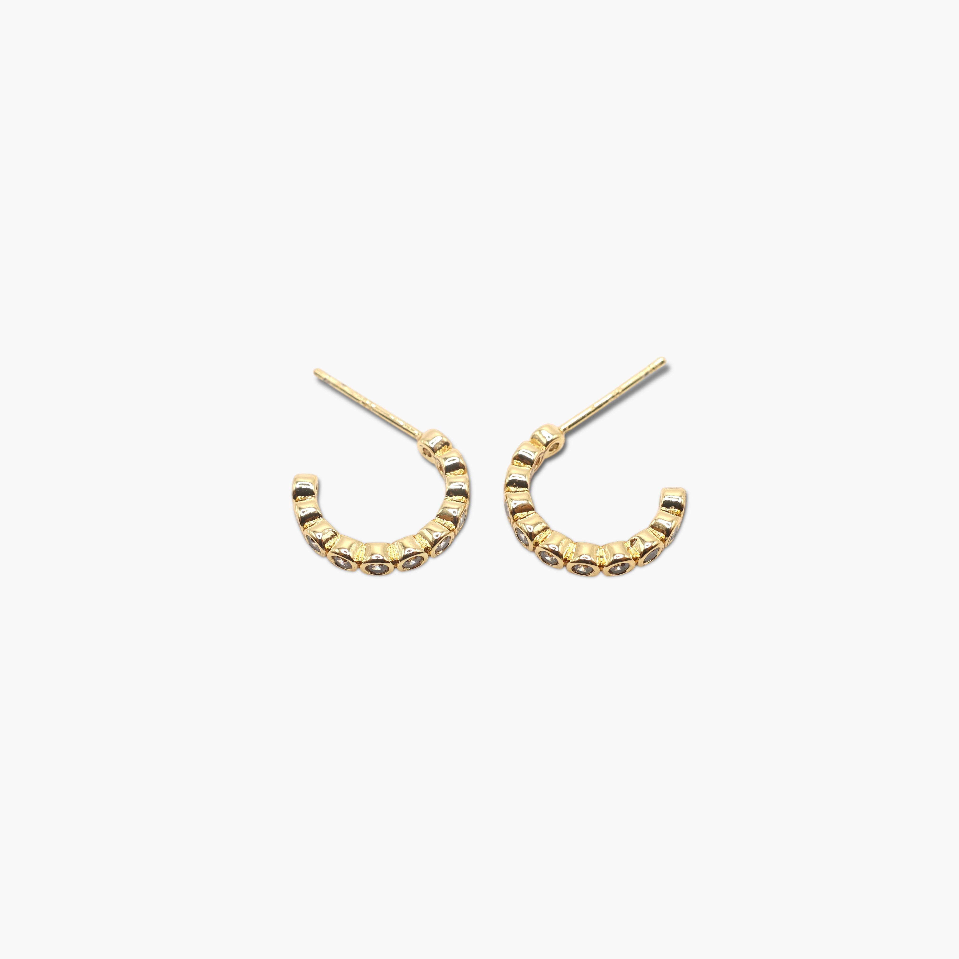 A pair of gold-colored hoop earrings with a textured surface on a white background.