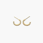 A pair of gold-colored hoop earrings with a textured surface on a white background.