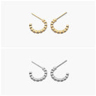 A pair of gold-colored hoop earrings with open hoops and small dangling embellishments.