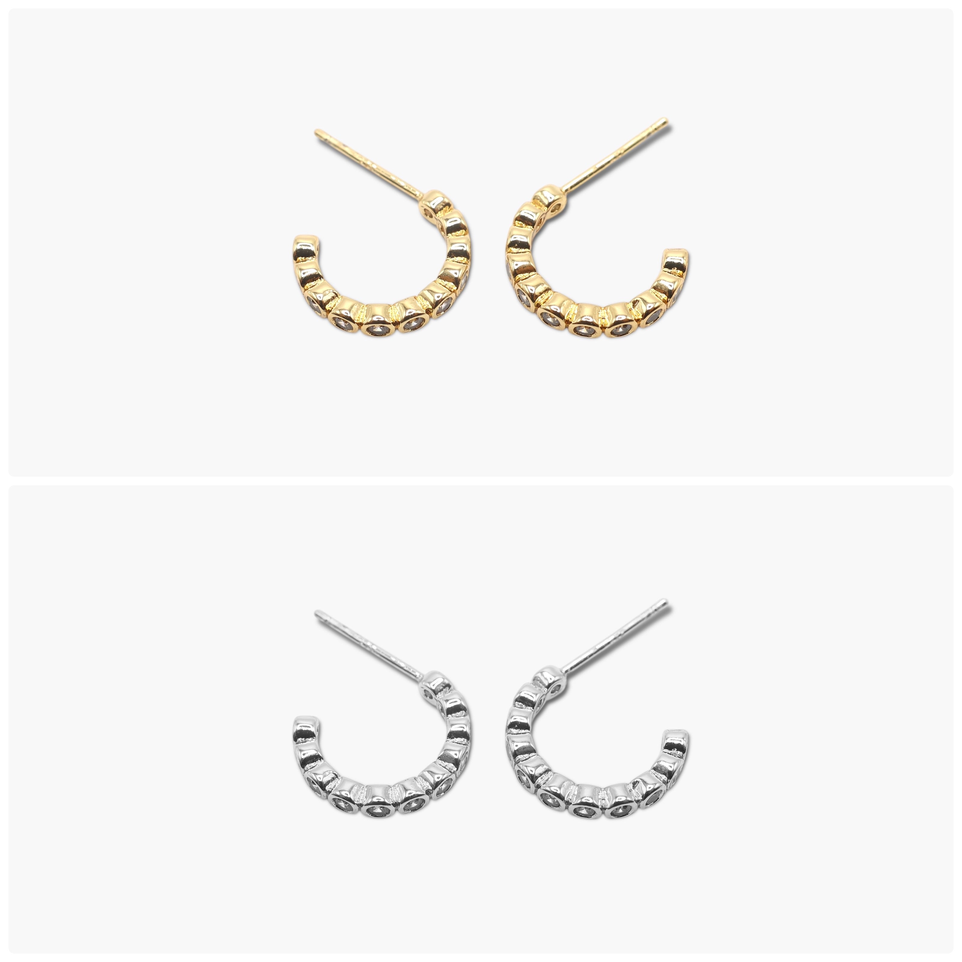 A pair of gold-colored hoop earrings with open hoops and small dangling embellishments.