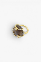 Polished natural stone statement ring with crystal accents in a textured gold-tone setting.