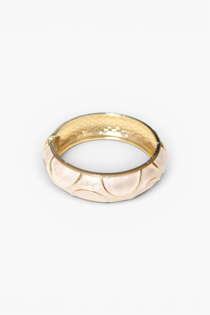 Gold ring with a textured design on a white background