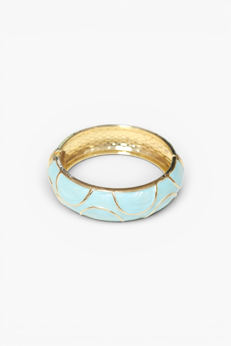 Gold ring with a light blue band on a white background