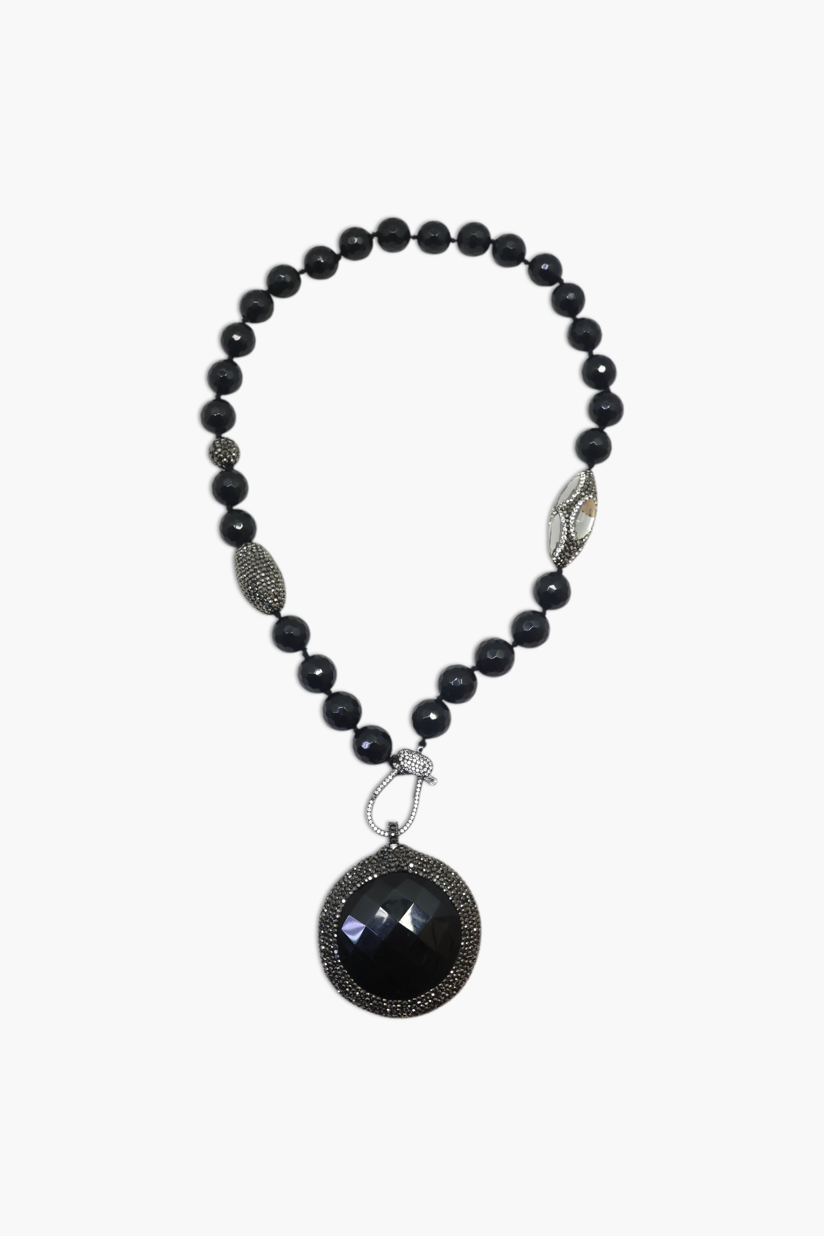 A person wearing multiple necklaces with onyx and gun metal colors.