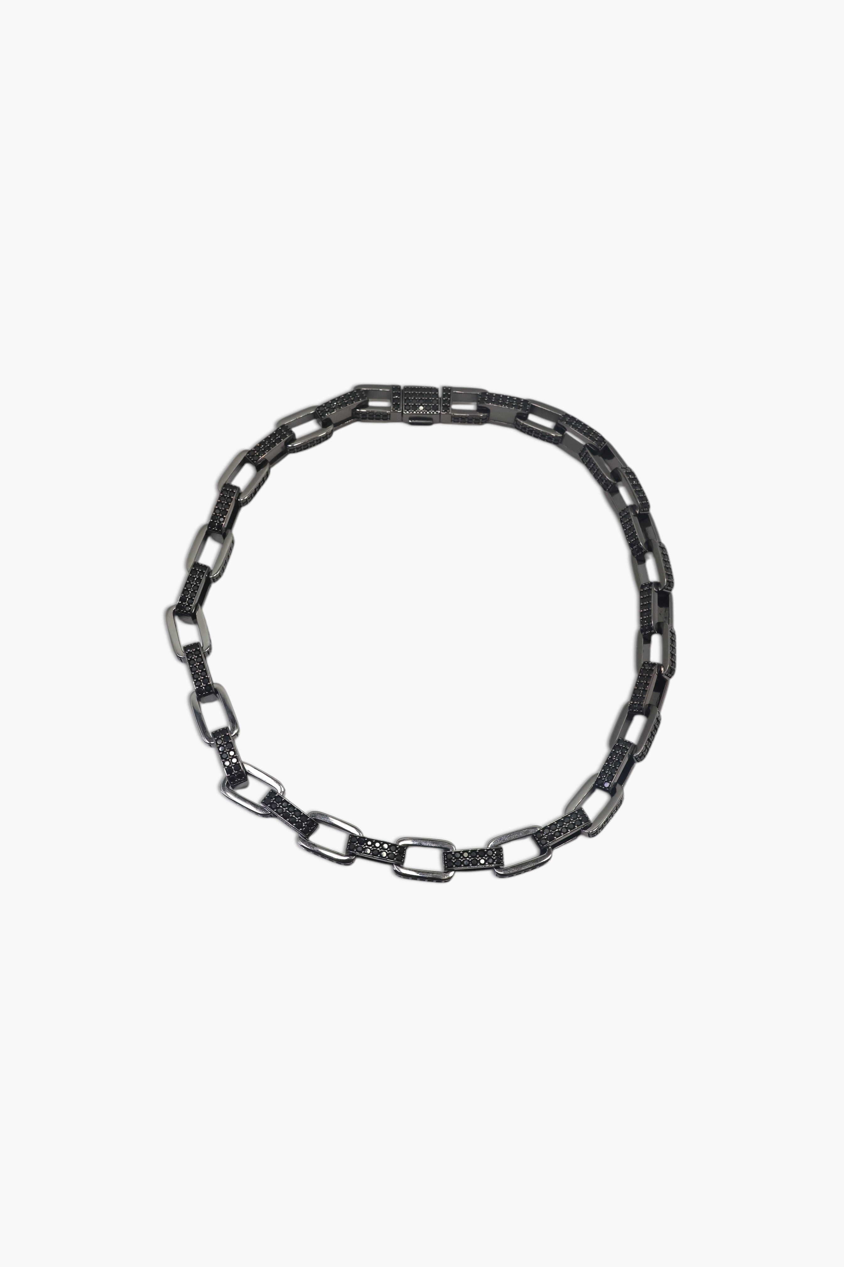 A person wearing multiple necklaces with onyx and gun metal colors.