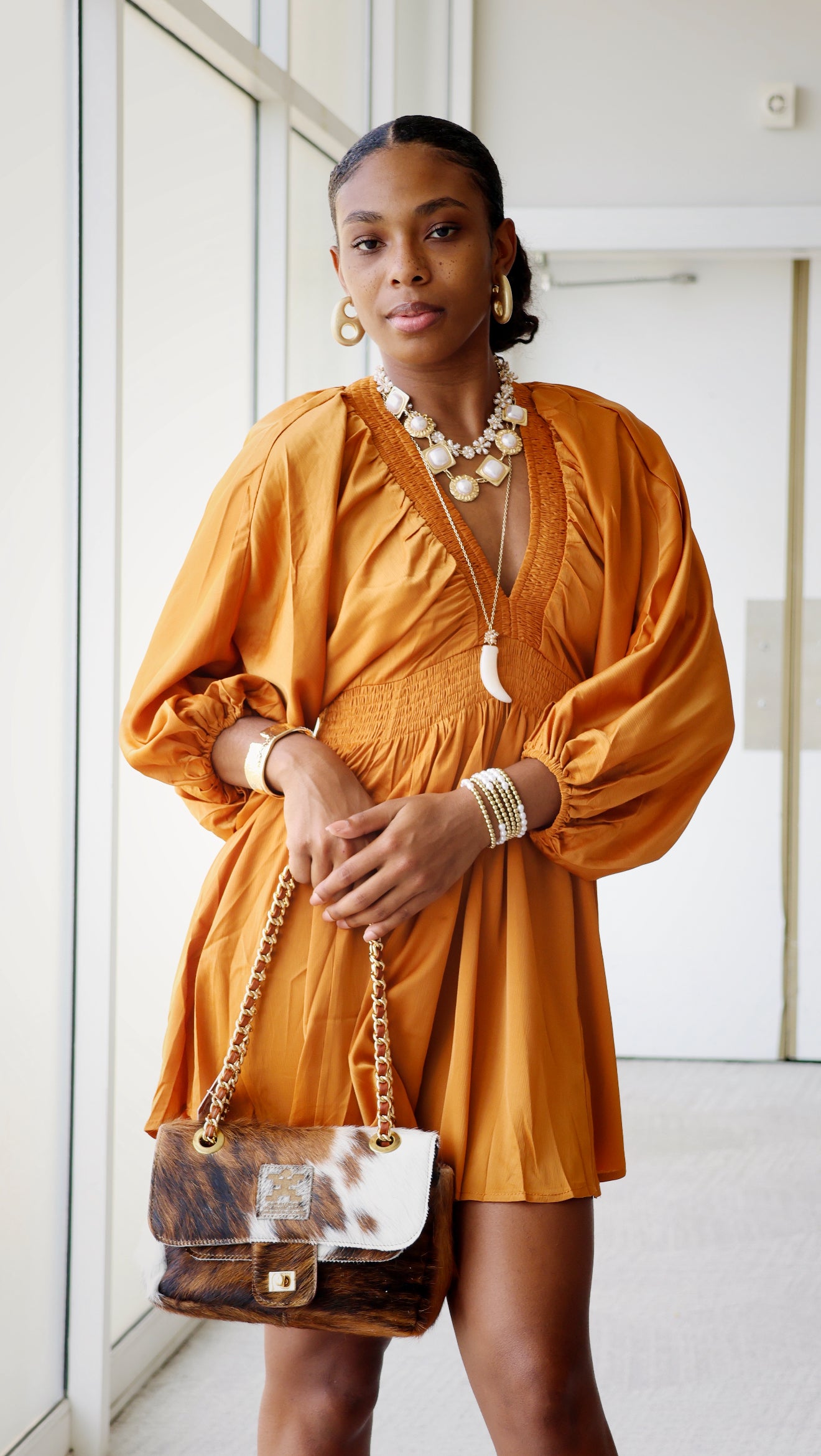 Woman wearing a orange silk dress with a white background