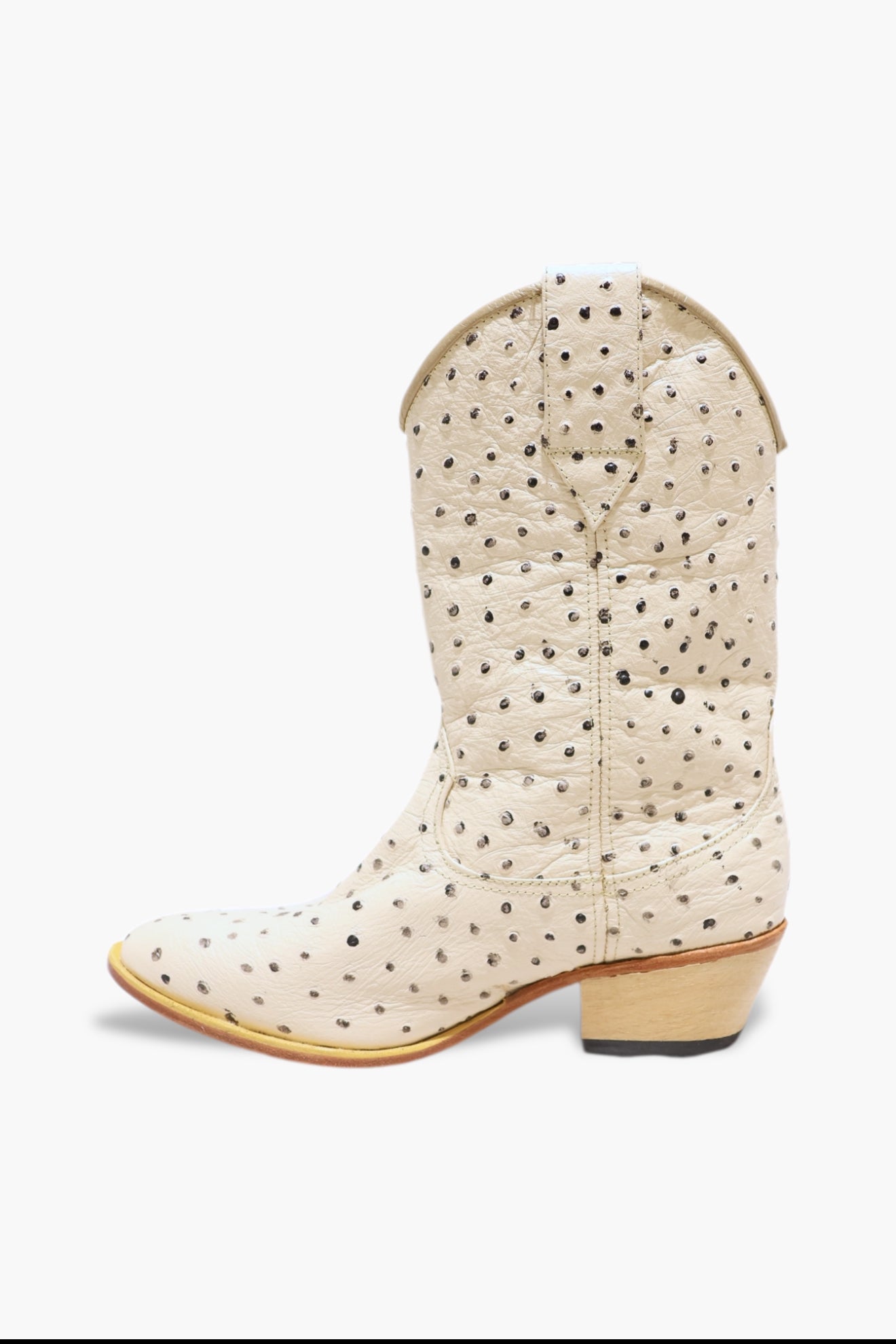 White cowboy boot with black polka dots on a white background