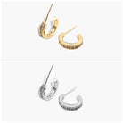 A pair of gold-colored hoop earrings with open hoops and small dangling embellishments, displayed against a white background.