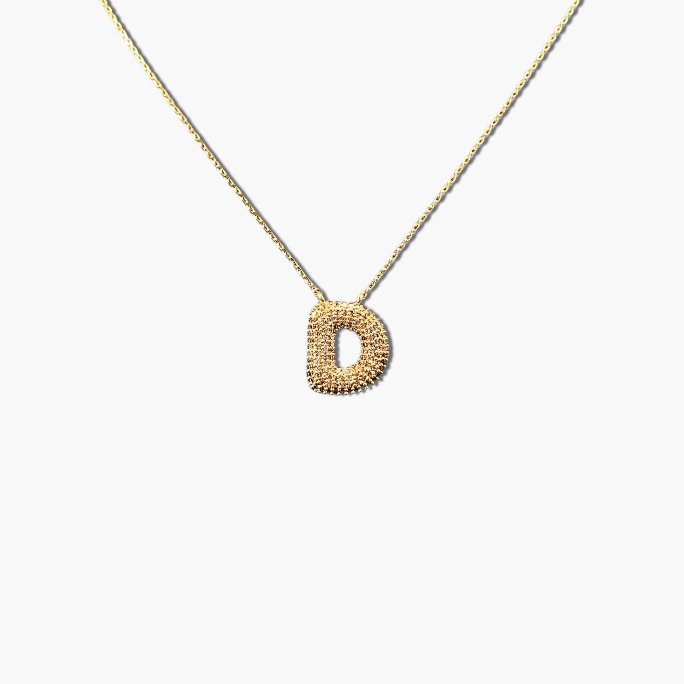 A gold-plated letter necklace with a pleated design on the pendant.