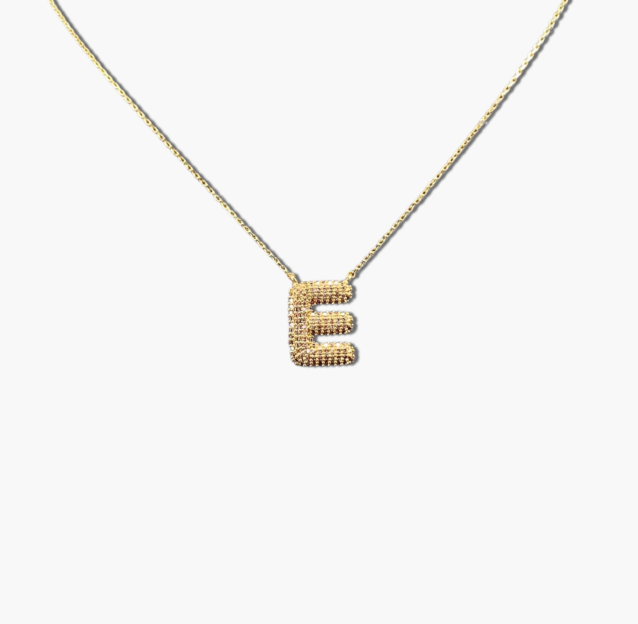 A gold-plated letter necklace with a pleated design on the pendant.