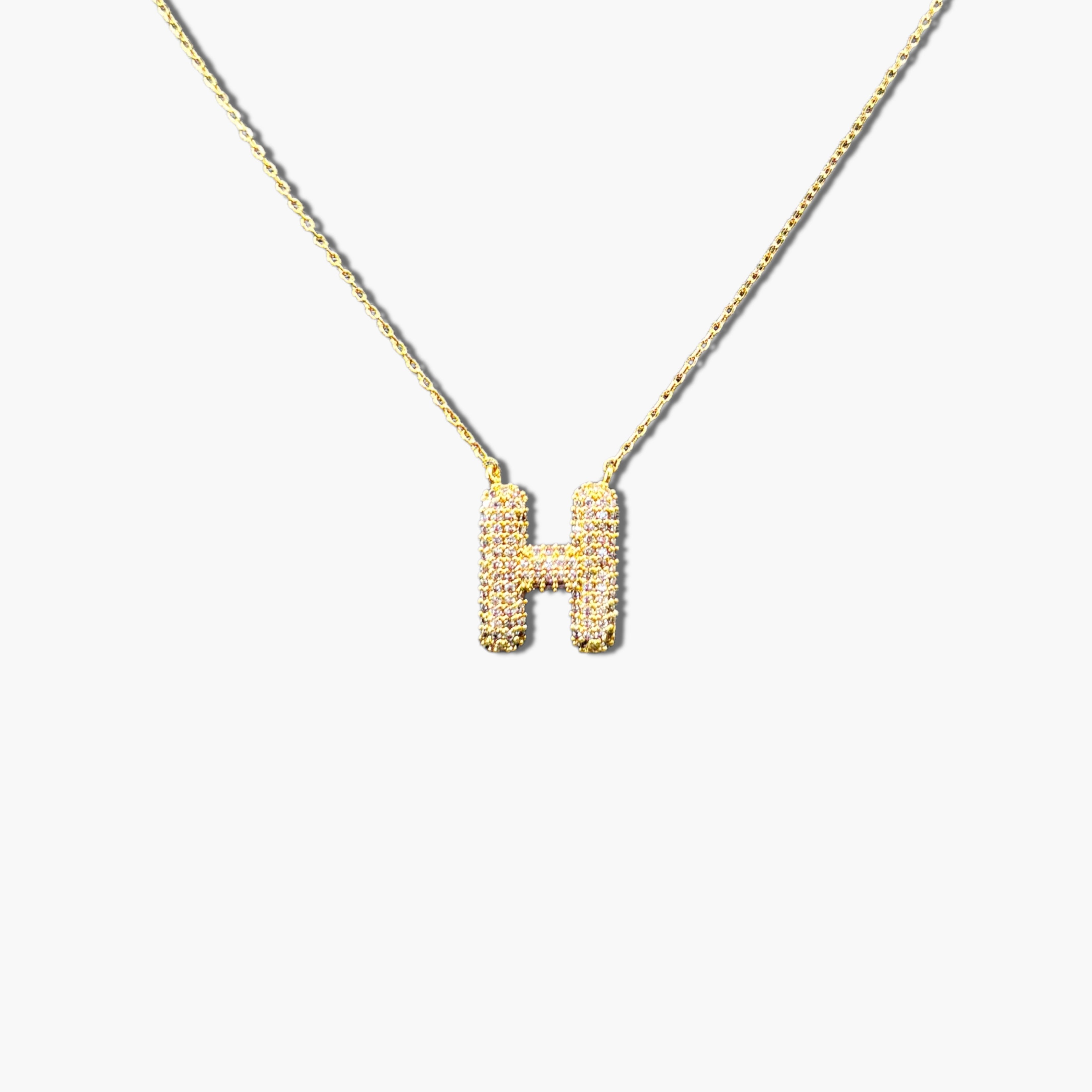 A gold-plated letter necklace with a pleated design on the pendant.