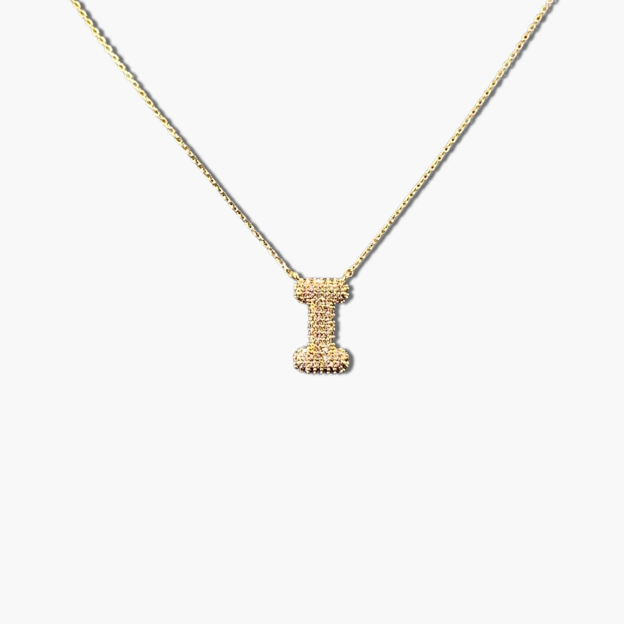 A gold-plated letter necklace with a pleated design on the pendant.