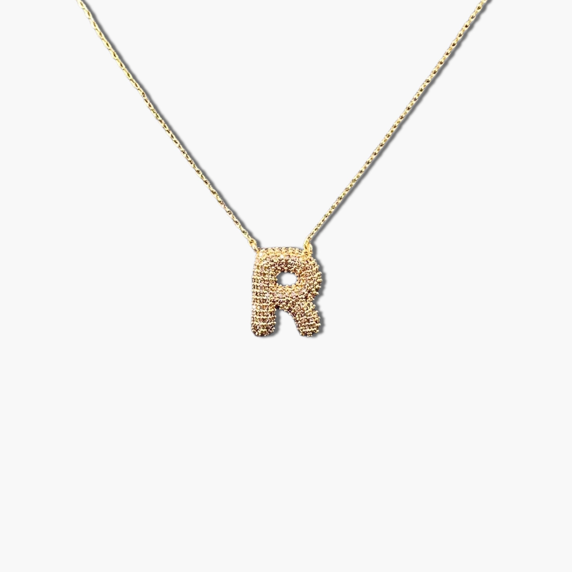 A gold-plated letter necklace with a pleated design on the pendant.