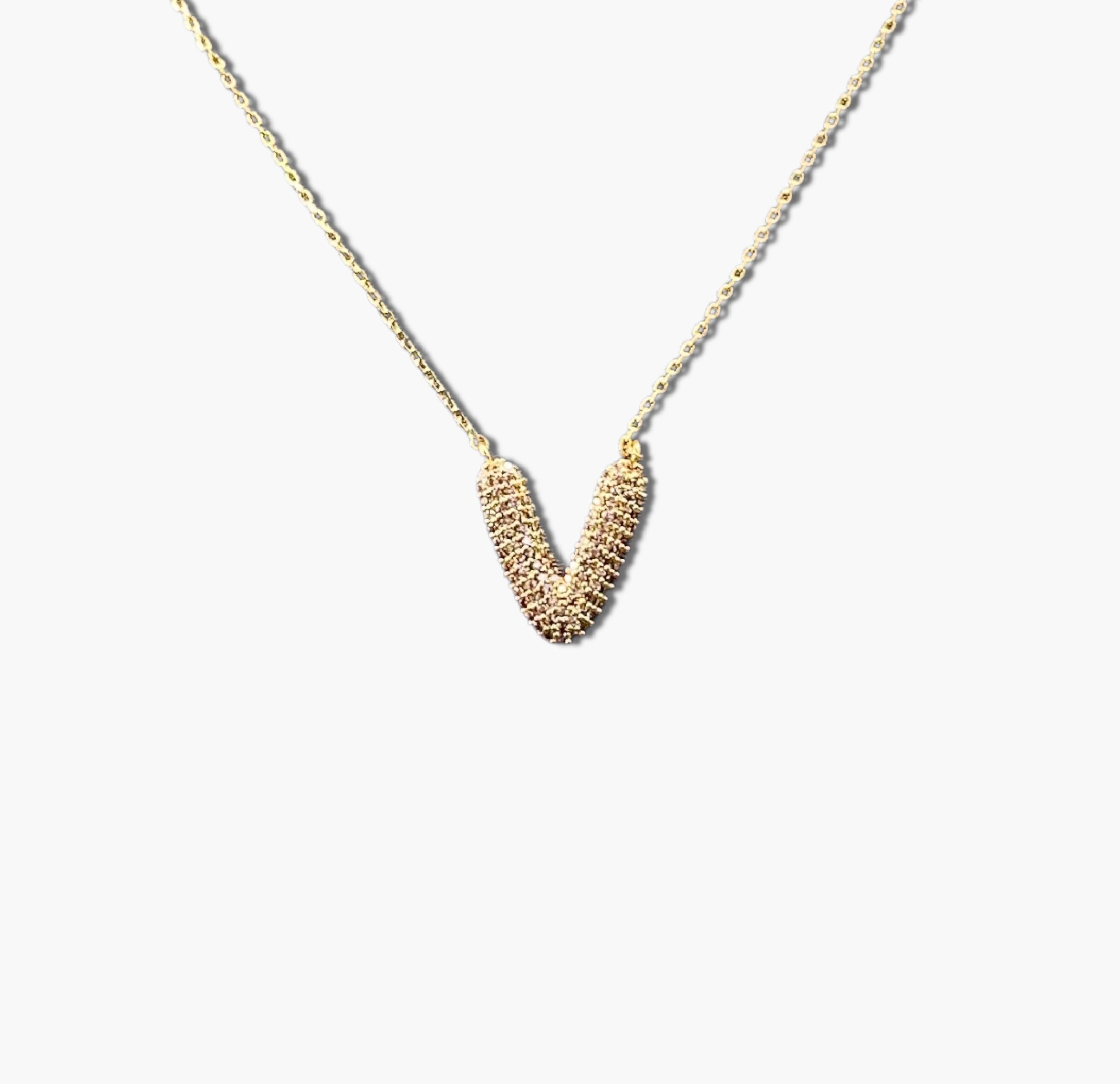 A gold-plated letter necklace with a pleated design on the pendant.