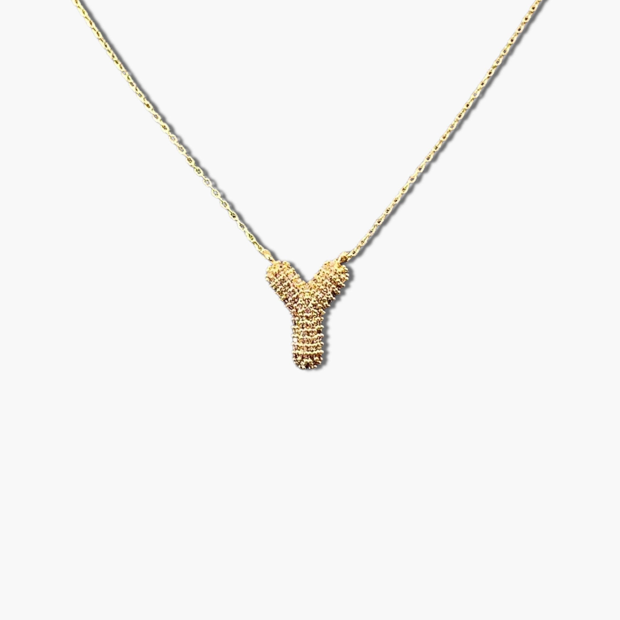 A gold-plated letter necklace with a pleated design on the pendant.